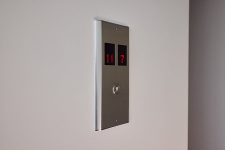 Pressing the elevator button in contemporary high rise buildings signifies modern urban convenience