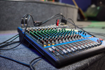 Closeup image of a control board with audio mixing capabilities, showcasing various buttons and...