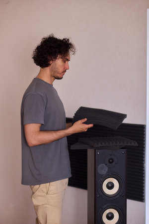 Setting up audio equipment with soundproofing panels in a modern studio environmentの写真素材