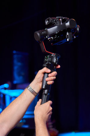 Closeup image showing someone gripping a DSLR camera with an articulated screen
