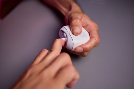 Close-up of an electric nail clipper in hand, modern personal care technology, highlighting compact...