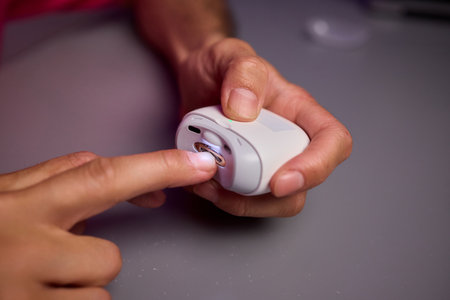 Close-up of an electric nail clipper in hand, modern personal care technology, highlighting compact...