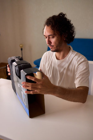 Unboxing a New Electronic Device with Great Care and Attention to Detail and Excitementの写真素材