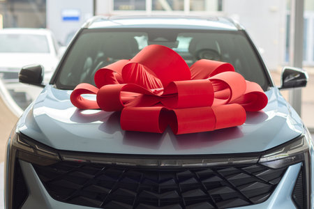 The new car is wrapped in a red bow. Beautiful gift concept.の写真素材