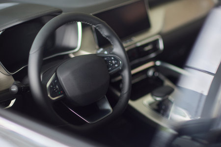 Closeup of a modern car steering wheel with control buttons for technology and convenienceの写真素材