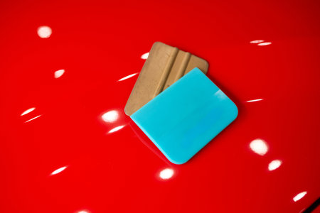 Brightly Colorful Squeegees Arranged on a Glossy Red Surface for Creative Appealing Displays