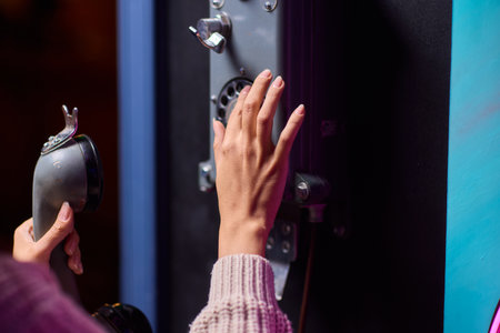 A Person Using a Payphone at Night in an Urban Setting, Highlighting Nostalgic Communication