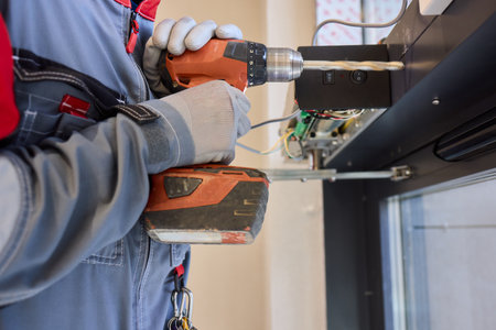 An Electrician Skillfully Installing Electrical Components Using a Power Drill Toolの写真素材