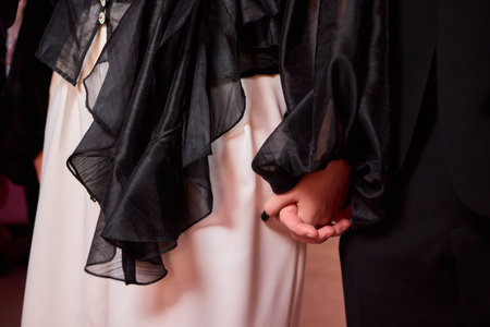 An Elegant Couple Holding Hands at a Formal Event Radiates Style and Affection Togetherの写真素材