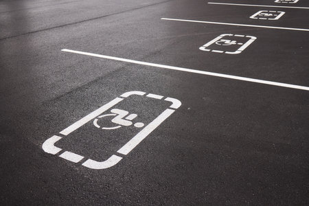 car parking space on asphalt, white worn markings, textured pavementの写真素材