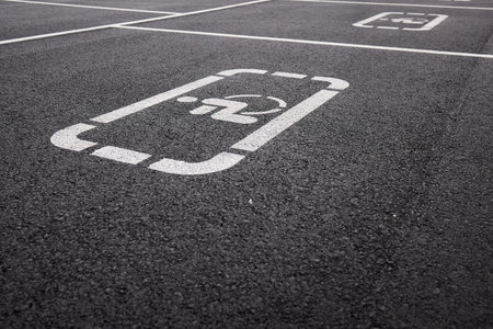 car parking space on asphalt, white worn markings, textured pavementの写真素材