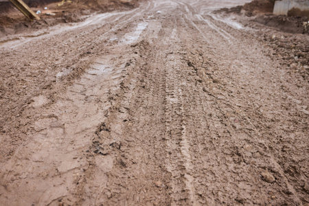 Rural muddy terrain, Uneven rural path with puddles, Challenging countryside trail with deep...