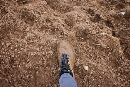 Muddy boot print, Worn leather footwear showing signs of outdoor work activity, Closeup of muddied...