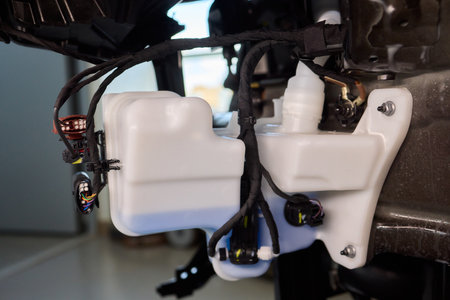 Closeup of coolant container during vehicle maintenance process, Technician topping off coolant...