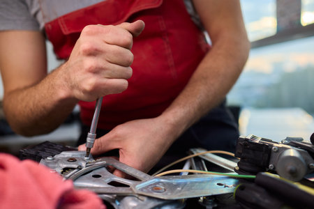Focused technician conducts precise motor repairs, Dedicated technician methodically finetunes small motor assembly with specialized tools in workshop environmentの写真素材