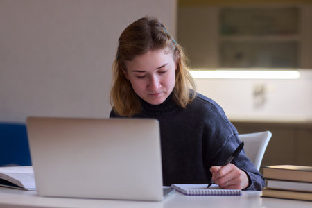 Determined individual immersed in educational activities indoors, Courageous woman concentrates on studying at home with dedicationの写真素材