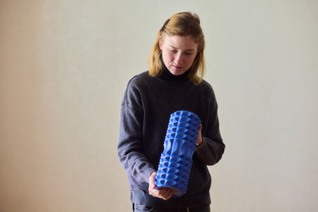 Woman exercises indoors, Individual with cerebral palsy performing warmup, Serene young woman with mobility challenges practicing controlled physiotherapy routines indoorsの写真素材