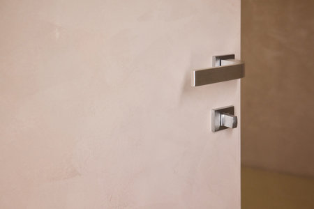 Modern beige door handle detail, Closeup of stylish door handle with lighting, Detailed view of sleek chrome door handle emphasizing design and calming atmosphereの写真素材