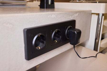 Power hub setup, Closeup of mounted power strip with multiple connections and cables, technician...