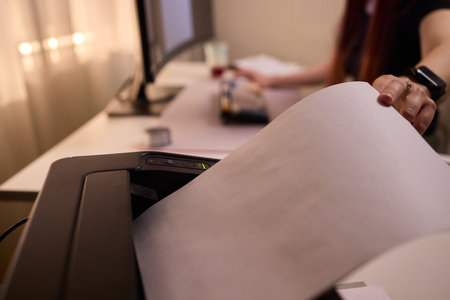 Work environment with paper loading, Assistant inserting paper into laser printer desk, Quiet office...