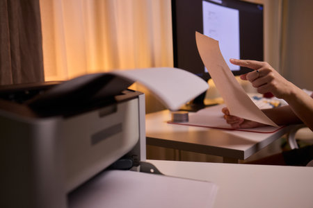 Closeup of professional reviewing agreement documents diligently, Dedicated editor engaged in...