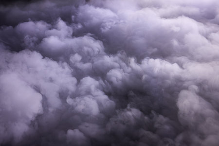 Smoky atmospheric scene, Mysterious purple smoky panorama, Layered fog with violet hues and swirling clouds, Aerial view showing thick smoke with colorful haze and depthの写真素材