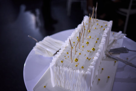 Couple shares wedding cake, Bride and groom enjoy their special cake moment together, Bride and groom cheerfully cut their elegant wedding cake amid joy and celebrationの写真素材