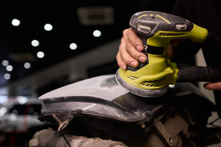 Hands refining car lamps professionally, Orbital buffer restoring clarity to headlights, Closeup of...