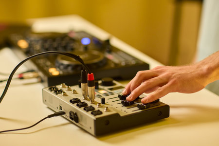 Closeup of tactile controls and vibrant patch cords in studio, Adjusting analog sequencing equipment with bright cables and warm ambient lighting in home studioの写真素材
