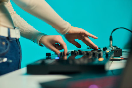 DJ setup overview, Energetic club DJ performing with digital controller in action, Content creator mixing music live using digital turntables under vibrant stage lightsの写真素材