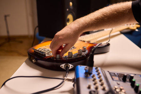 Musician setting up equipment, Preparing bass guitar for recording, Electric bass player organizing...