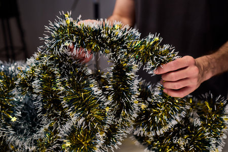 Closeup of hands preparing decorations, People arranging sparkling tinsel for celebration,...