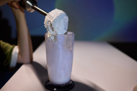 Creamy scoop presentation, Barista serving frosty ice cream, Indulgent treat being carefully plated...