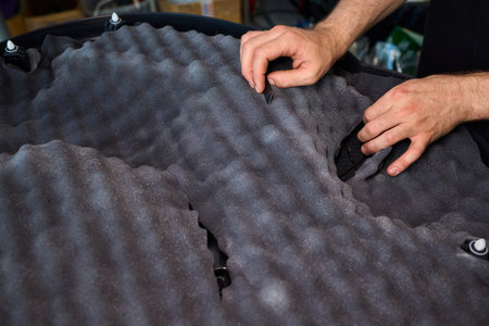 Hands Skillfully Engaged in the Construction of an Acoustic Foam Structure and Installationの写真素材