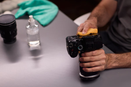 Technician cleaning lens mount contacts carefully, using microfiber to remove dust and debris, zoom...
