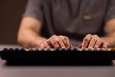 Keyboard typing focus. Closeup of fingers pressing keys with vintage style switches. Studio shot of...