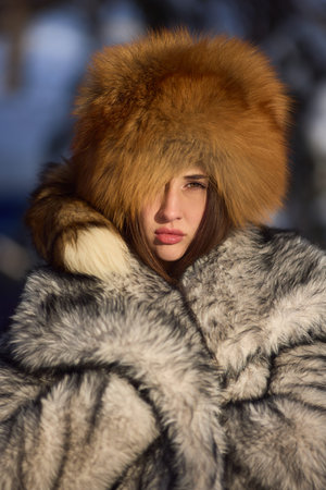 Serene woman dressed for cold weather. Closeup of tranquil woman wearing cozy winter clothing. Woman...