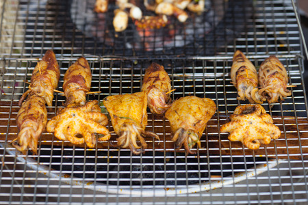 Squid and octopus fried with spices on grill over an open fireの写真素材