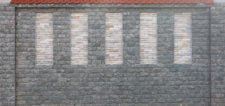Detail of modern stone wall with red tiled roof. Textural background