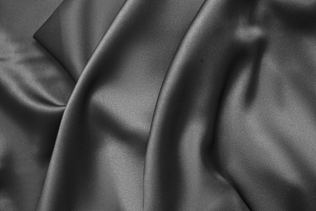 Black luxury wavy rippled glossy silk drapery cloth fabric. Abstract backgroundの写真素材