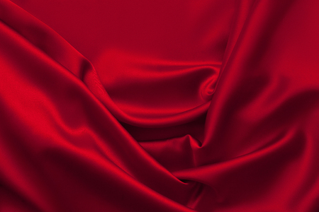 Luxury red shiny satin fabric cloth abstract wavy backgroundの写真素材
