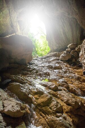 Stone cave inside view. Light exit from dark underground. Speleology or geology conceptの写真素材