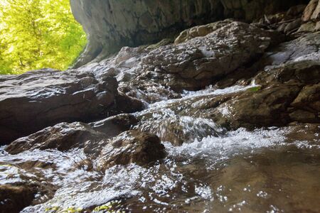 Mountain river creeck flowing in dark cave. Tropical nature viewの写真素材