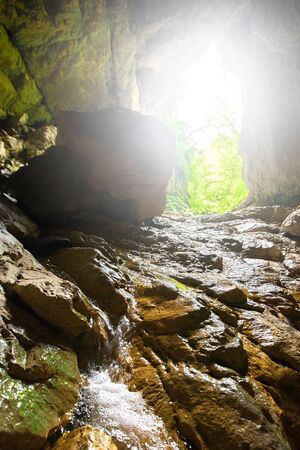 Stone cave inside view. Light exit from dark underground. Speleology or geology conceptの写真素材