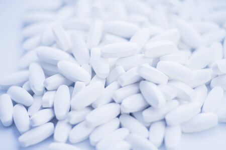 White pills heap blured background. Medicine conceptの写真素材