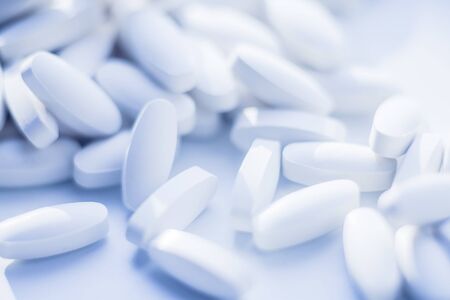 White pills heap blured background. Medicine conceptの写真素材