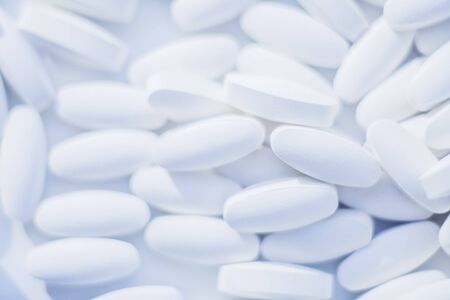 White pills heap blured background. Medicine conceptの写真素材
