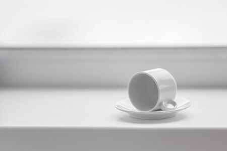 Empty white coffee cup on windowsill. Morning breakfast concept backgroundの写真素材