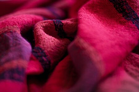 Red woolen fabric cloth background. Wavy texture purple material