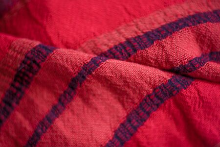 Red woolen fabric cloth background. Wavy texture purple material
